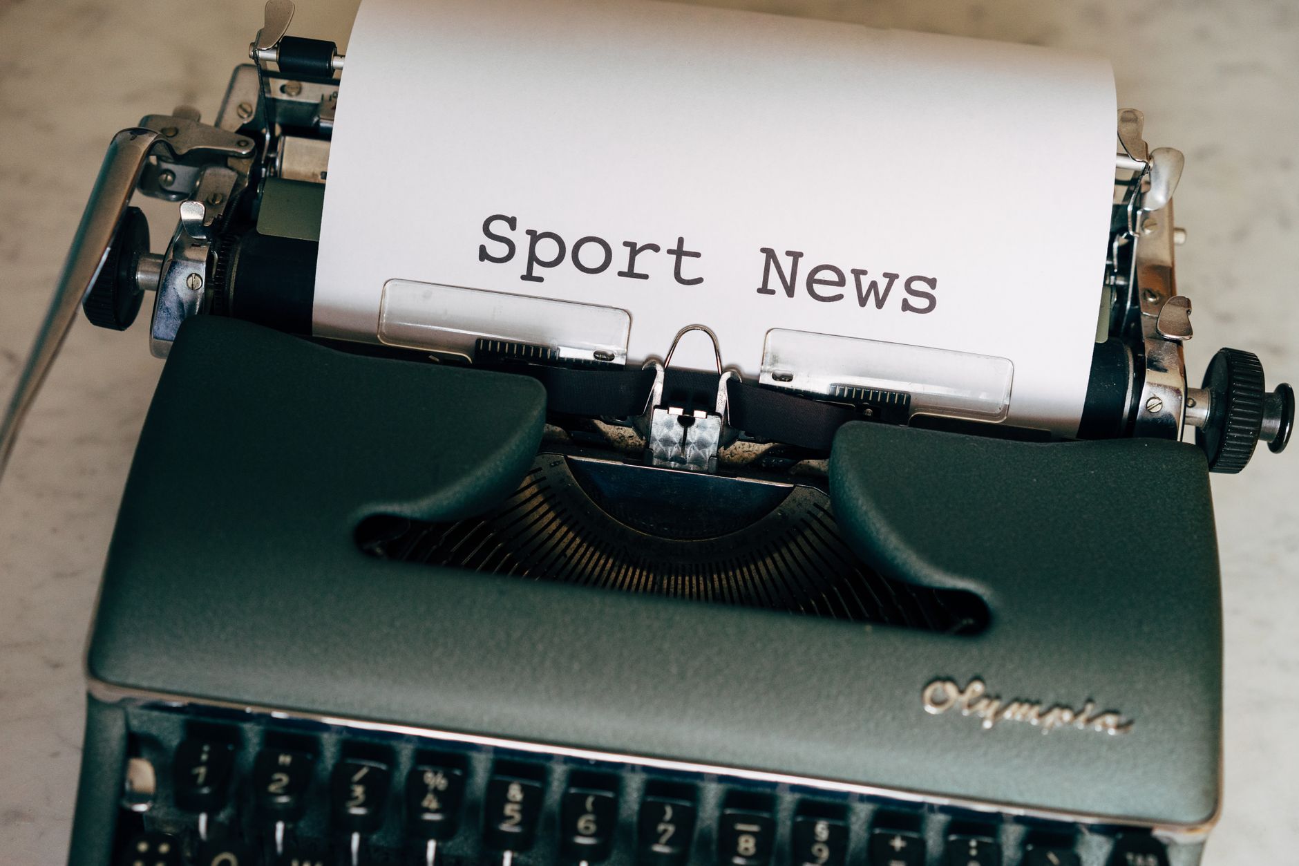Close-up of a vintage typewriter with a paper showing 'Sport News', evoking nostalgia and classic journalism. — Die Benutzerf