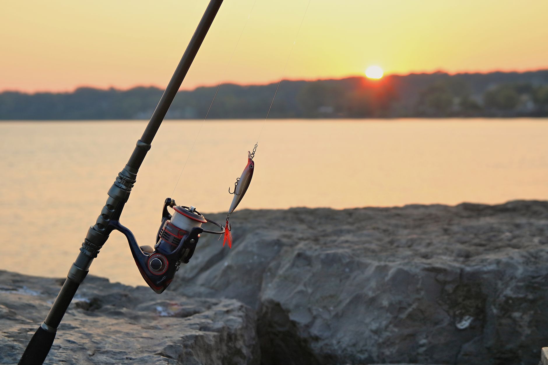 Fishing rod and lure at sunrise on a rocky pier in Webster Lake, NY. — Die Rolle des Kundenservice bei Rakoo Casino