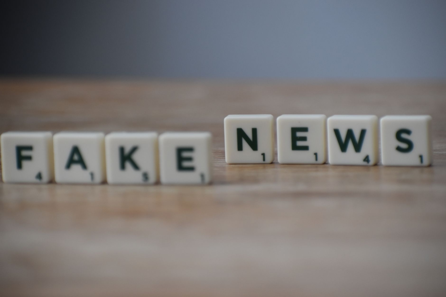Scrabble tiles spelling 'Fake News' on a wooden surface highlighting misinformation. — Die Zahlungsmethoden im Test: Only Spi