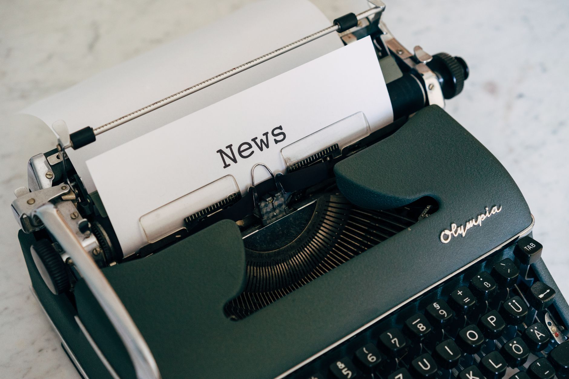 Close-up of an antique typewriter with 'News' on paper. — Welchen Einfluss hat die Software von Tron Casino auf das Spiel?