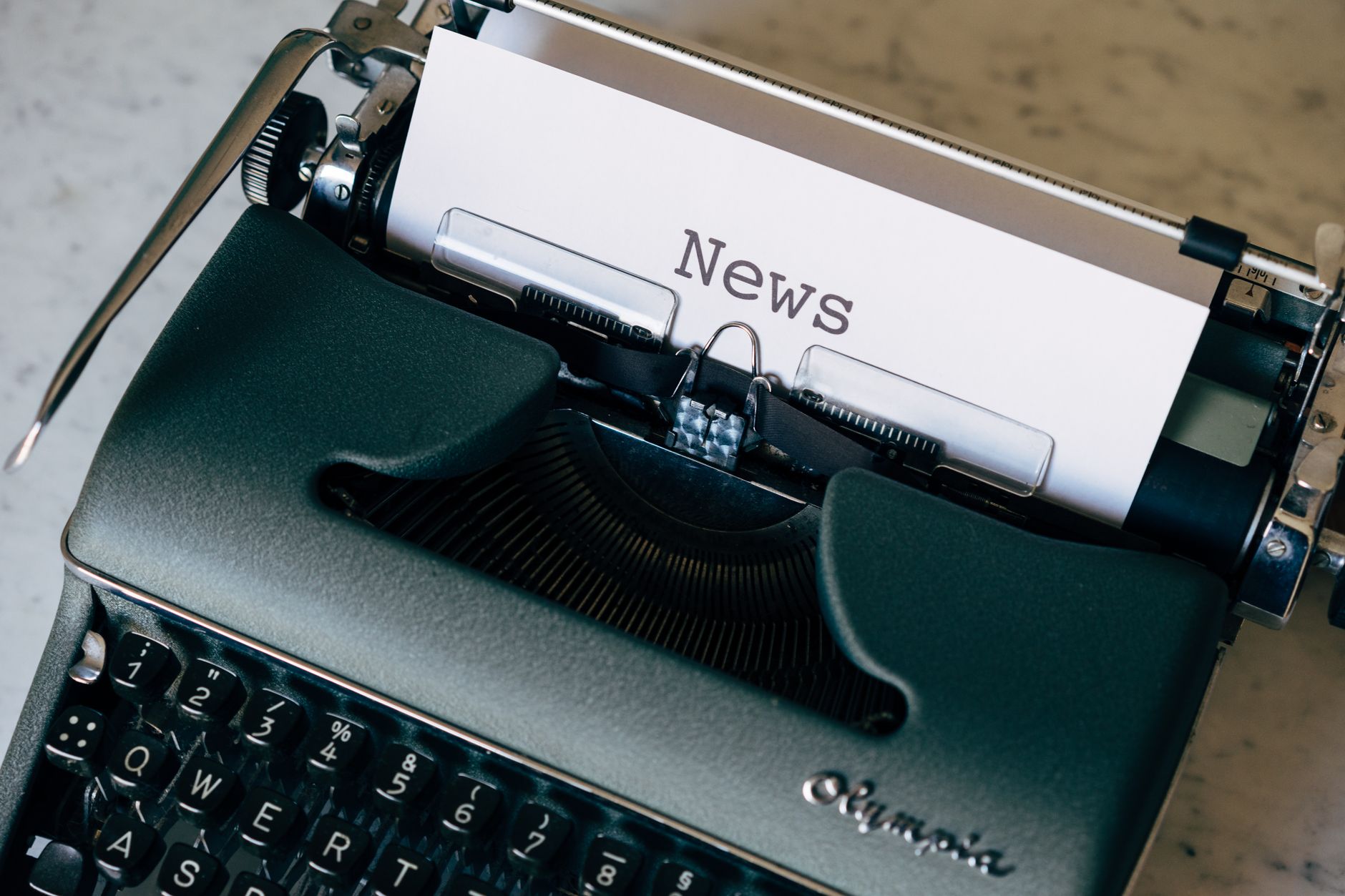 A vintage typewriter with a paper titled 'News', symbolizing journalism and communication. — Wie sieht der Spielbetrieb im Re